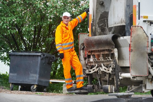 Operatives safely loading a skip as part of rubbish removal services